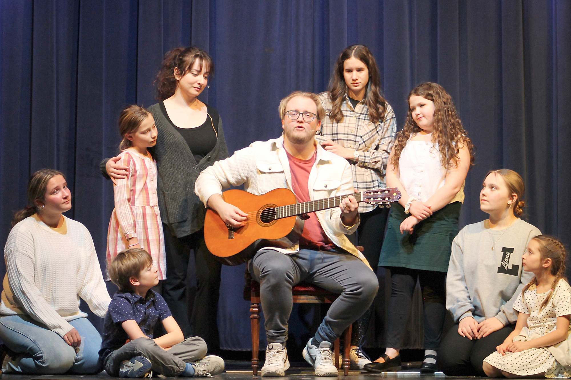 Performing “Edelweiss” at a rehearsal for The Sound of Music at UMEI Christian High School is Lucas Froese as Georg surrounded by his cast members.