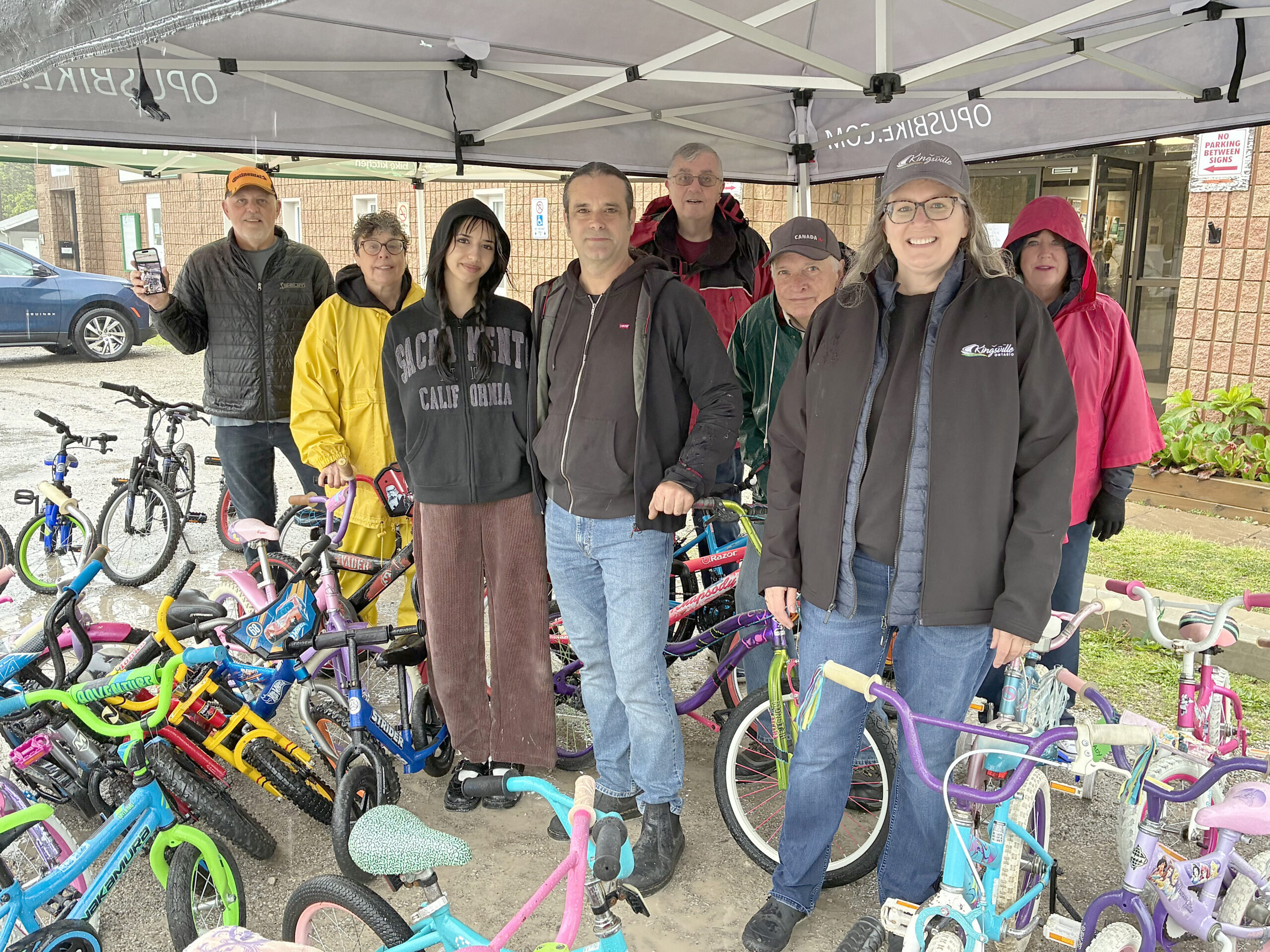 Ron Drouillard of Bike Windsor-Essex is pictured in the middle of the 50 bikes that were up for sale. To the left of Ron is his daughter Serena, and to his right is Kingsville Community Centre’s Kim DeYong. In the background are volunteers from the Community Centre who helped to make the day run smoothly.