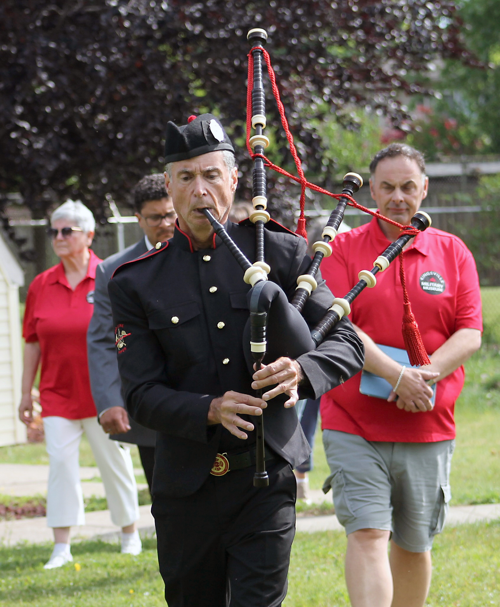Jonathan Paull plays the bagpipes while leading a procession during the D-Day commemoration ceremony in Kingsville on June 6.