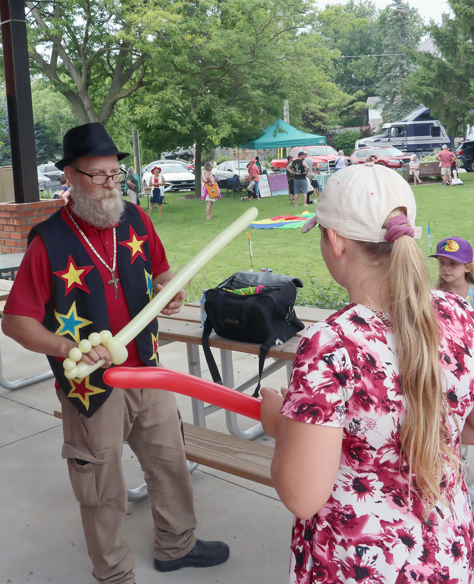 A balloon artist creates balloon animals for children during the Wheatley Fish Festival.