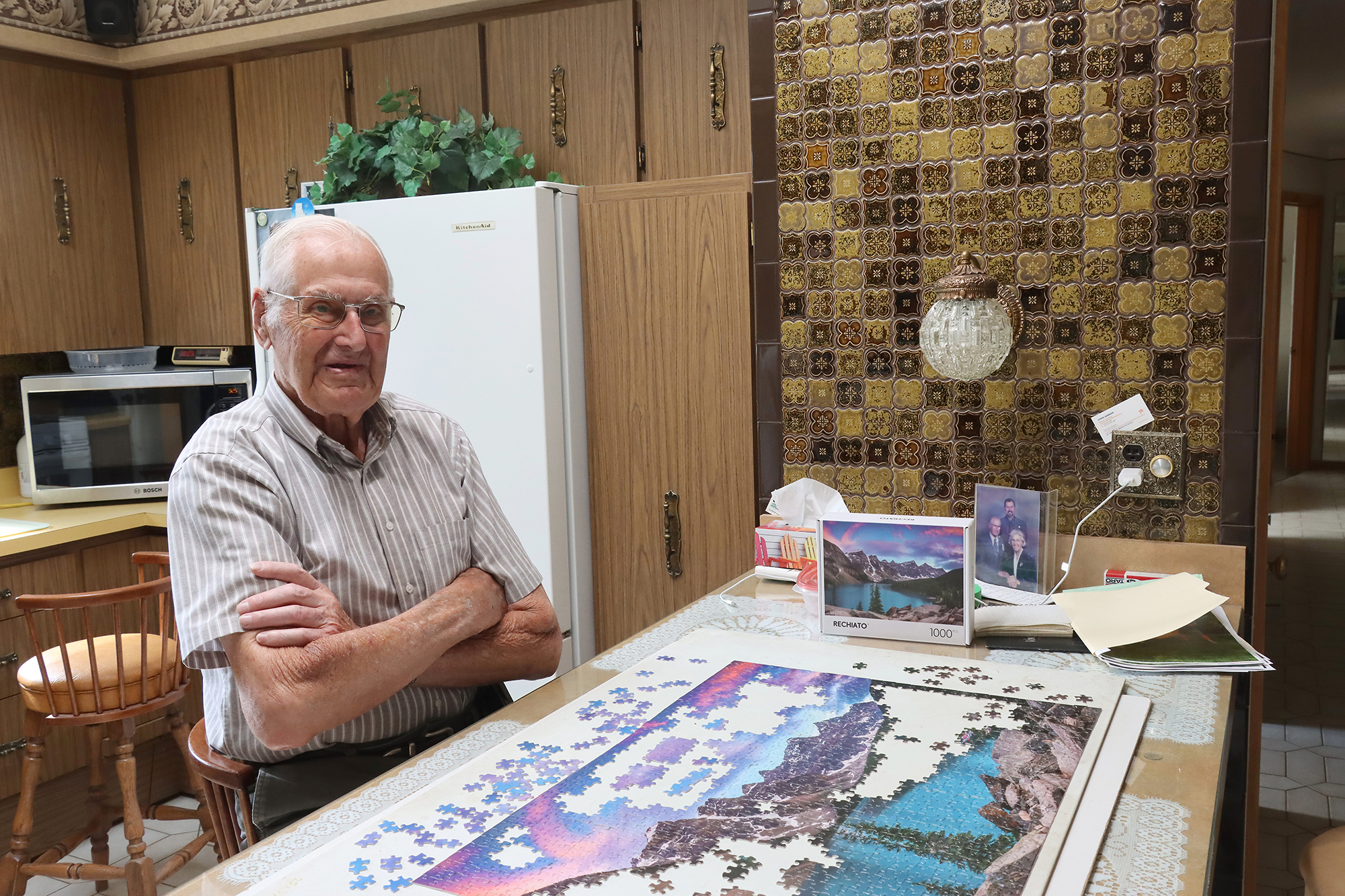 Ray Jaarsma works on a jigsaw puzzle at a table inside his Leamington home.