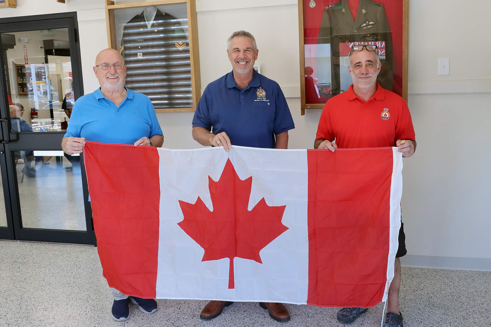MP Dave Epp presents a new Canadian flag to Wheatley Legion Branch 324 alongside Past President Dick Whittle and President Tom Brown.