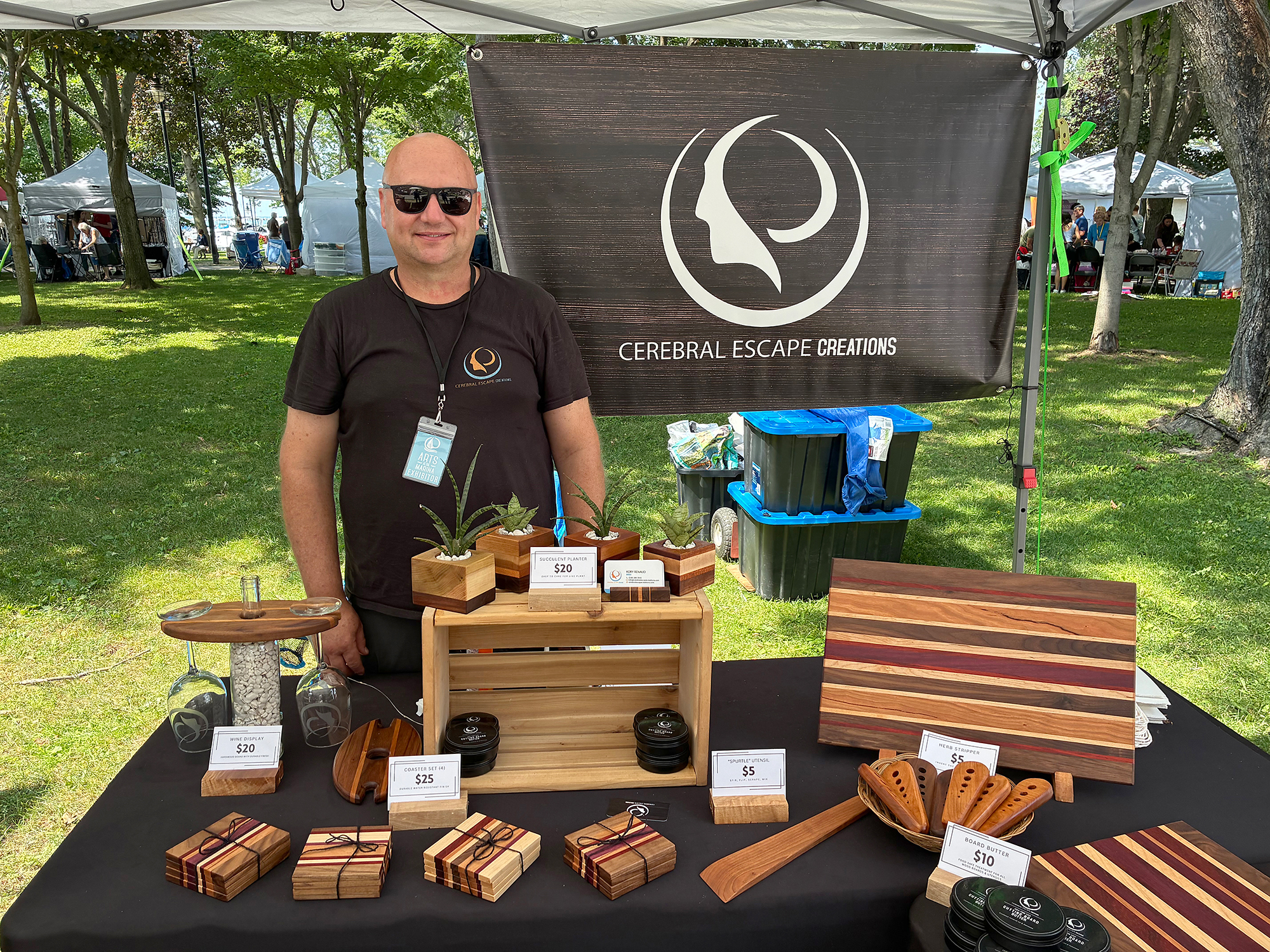 Kory Renaud of Cerebral Escape Creations displays handmade cutting boards, charcuterie boards, coasters and stands at Arts at the Marina 2026.