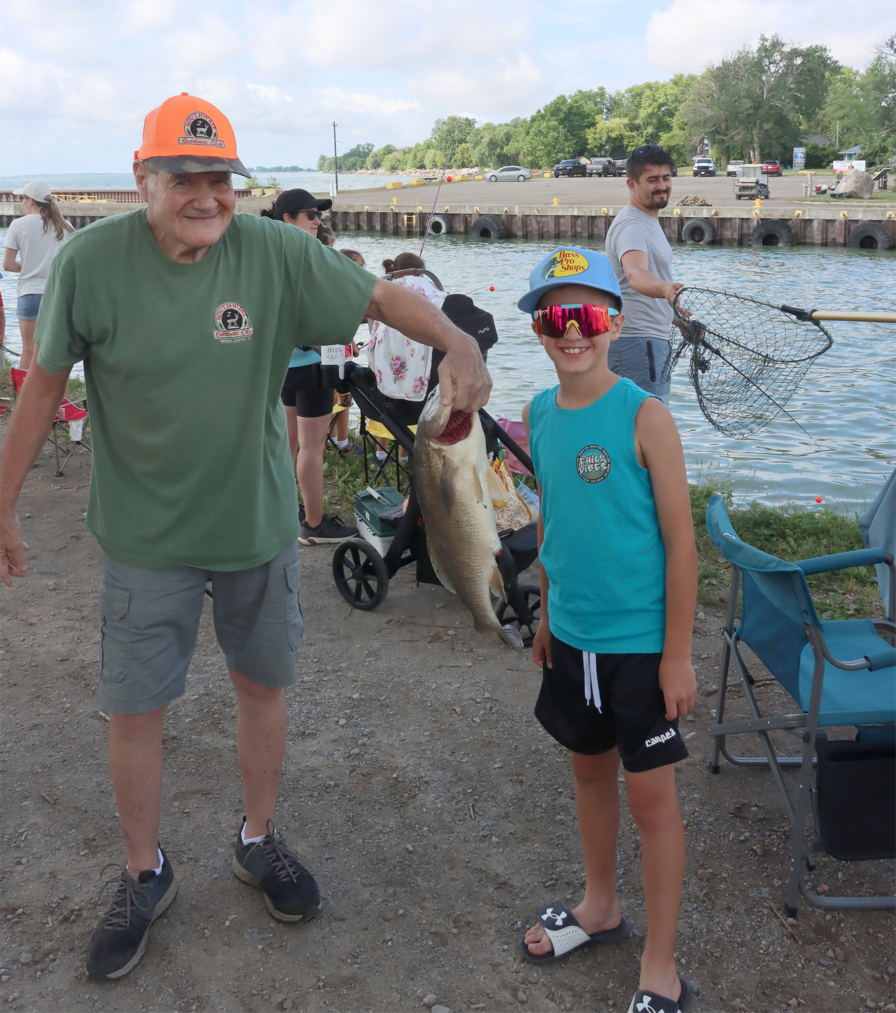 Young angler Dylan Coppola holds his 24.5-inch sheepshead, the largest fish of the day, as Don Wigle helps display the winning catch at the Southwest Outdoors Club Kids Fishing Derby.