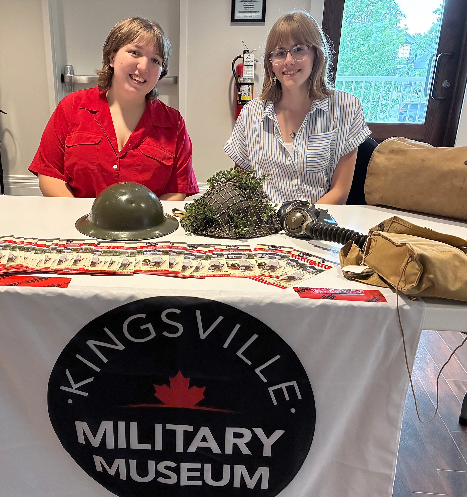 Sarah Denunzio, left, and Jane Larsen explain military artifacts from the Kingsville Military Museum to visitors at the indoor Kingsville Block Party.