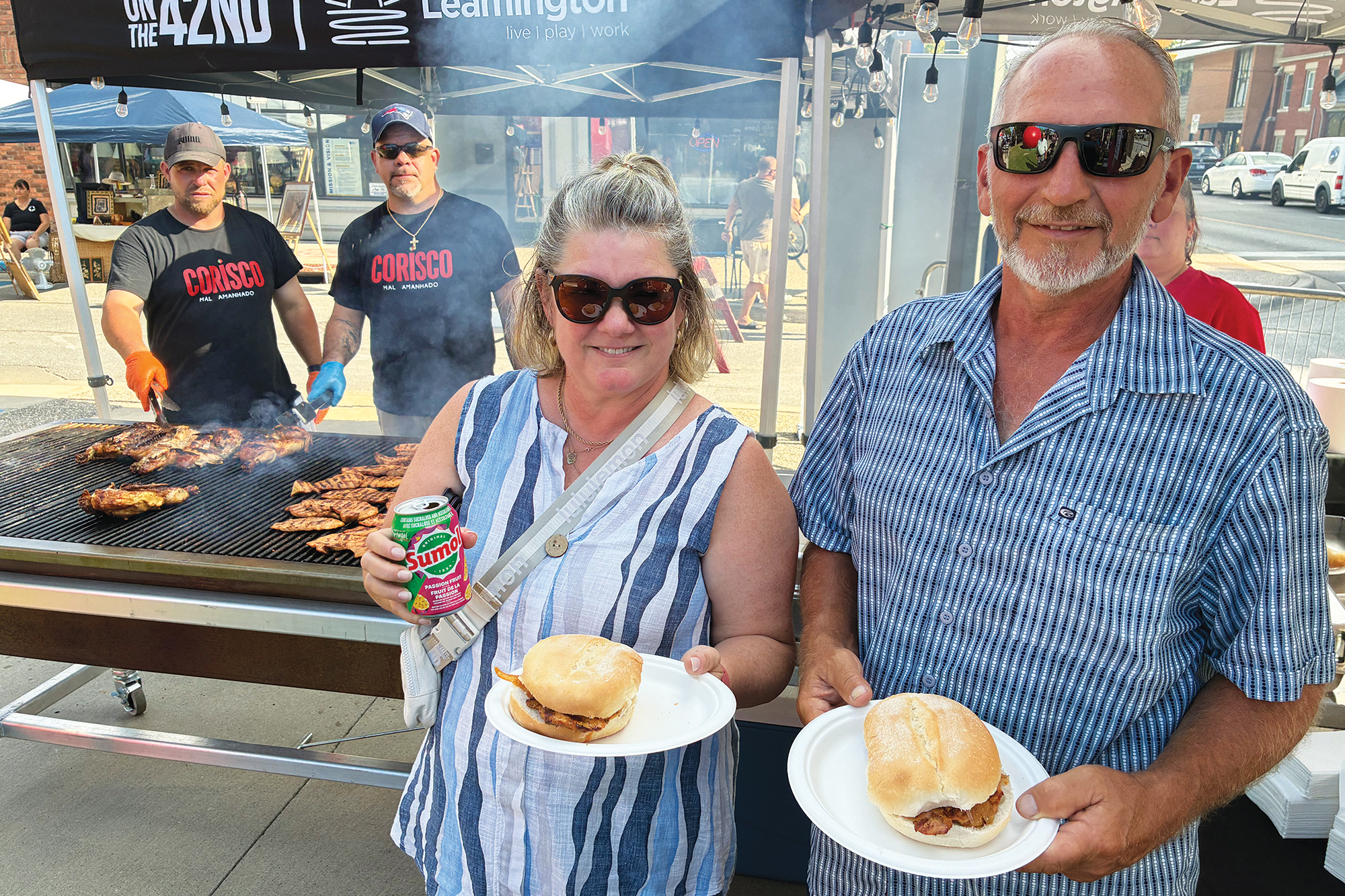 Ursula and Tim Tiessen purchase Portuguese bifanas from grill masters at the Mill Street Market in downtown Leamington.