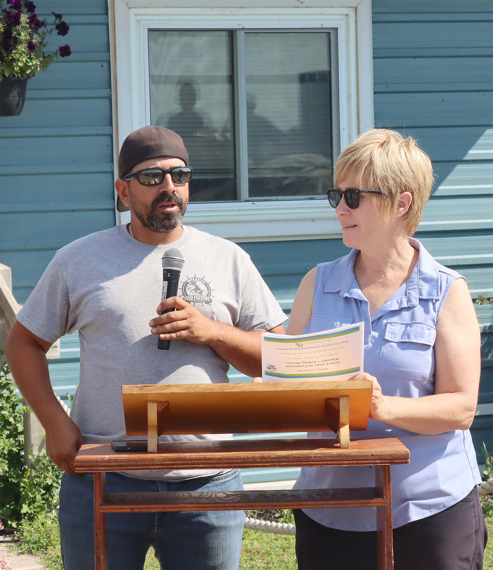 Wheatley Harbourmaster Bobby Cabral stands with plaque author Cindy Robichaud beside the new historical plaque honouring Wheatley's fishing heritage at Wheatley Harbour.