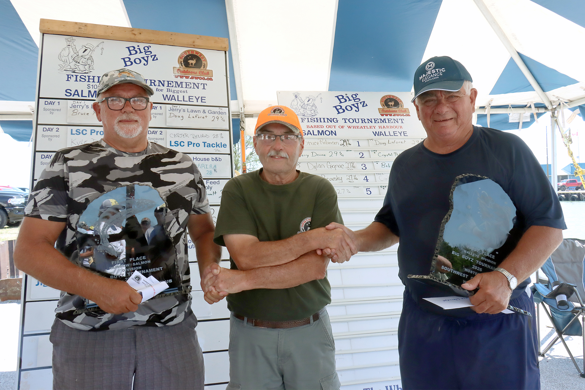 Bruce Robinson (left) and Doug Laforet, winners of the 2026 Big Boyz Fishing Derby for longest rainbow trout and longest walleye, pose with SWOC representative Dennis Reive at the awards presentation.