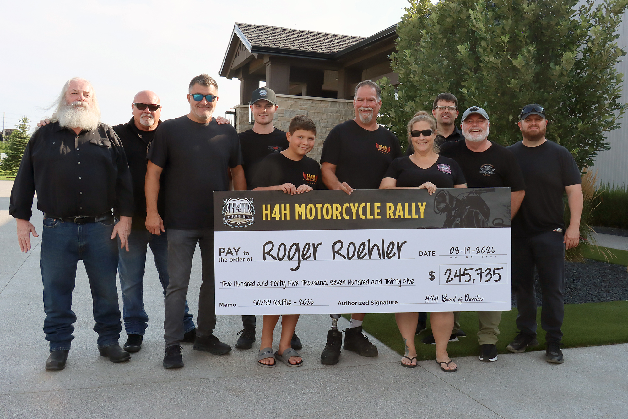 Hogs For Hospice raffle winners Kris Ennis and Roger Roehler with family members and Hogs For Hospice committee members at the prize presentation.