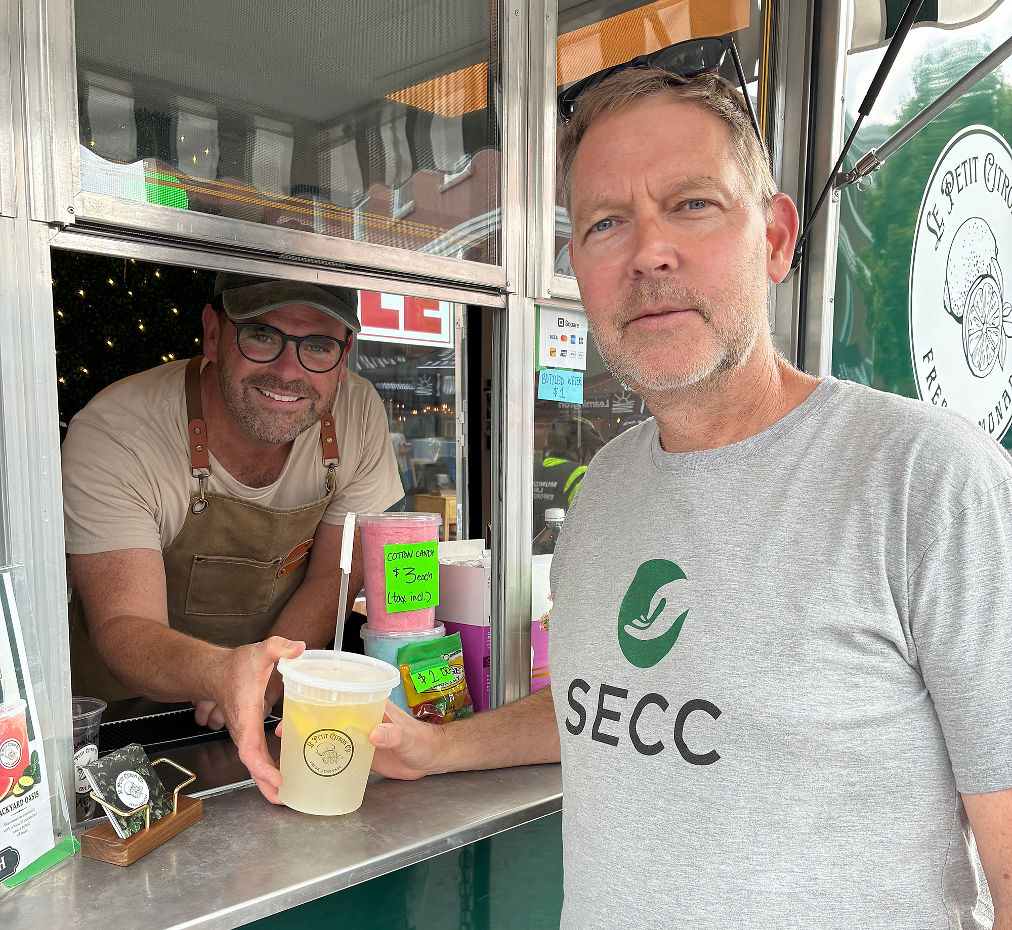 Eric Kruis receives a gourmet lemonade from Christopher Simard of Le Petit Citron Co. at the Mill Street Market.