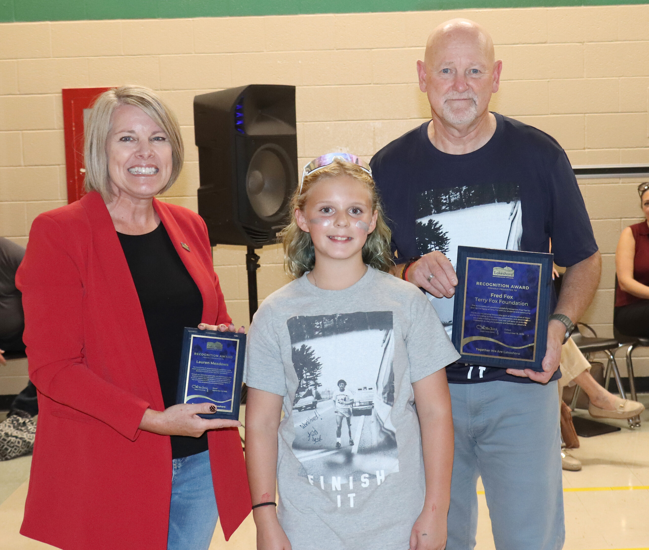 Lakeshore Mayor Tracey Bailey, left, presents plaques of appreciation to student Lauren Meadows and Fred Fox, who was visiting the school to spread his late brother’s message.