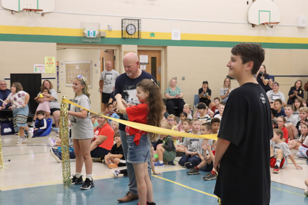 Megan Patrick — a two-time cancer survivor — cuts the ribbon with the help of Fred Fox, as friend Lauren Meadows, left and Megan’s brother Justin, hold the ribbon.