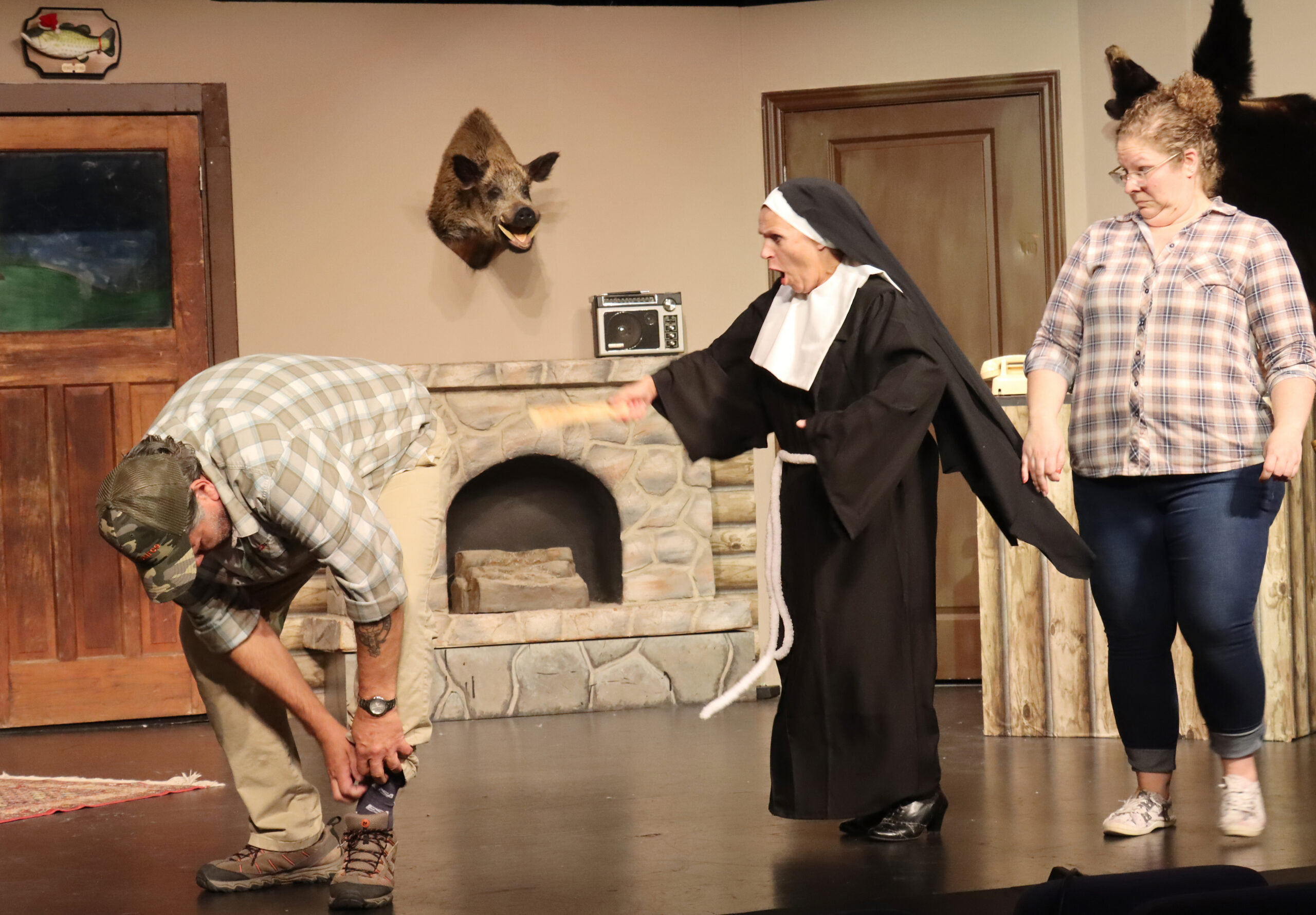 An unsuspecting D. Gene Wilburn (Corey Robertson) scratches an itch as Sister Myrtle Agnes (Linda Collard) prepares to rid him of his scratching habit. Wanelle Wilburn (Amy Brett) just doesn’t know what to think.